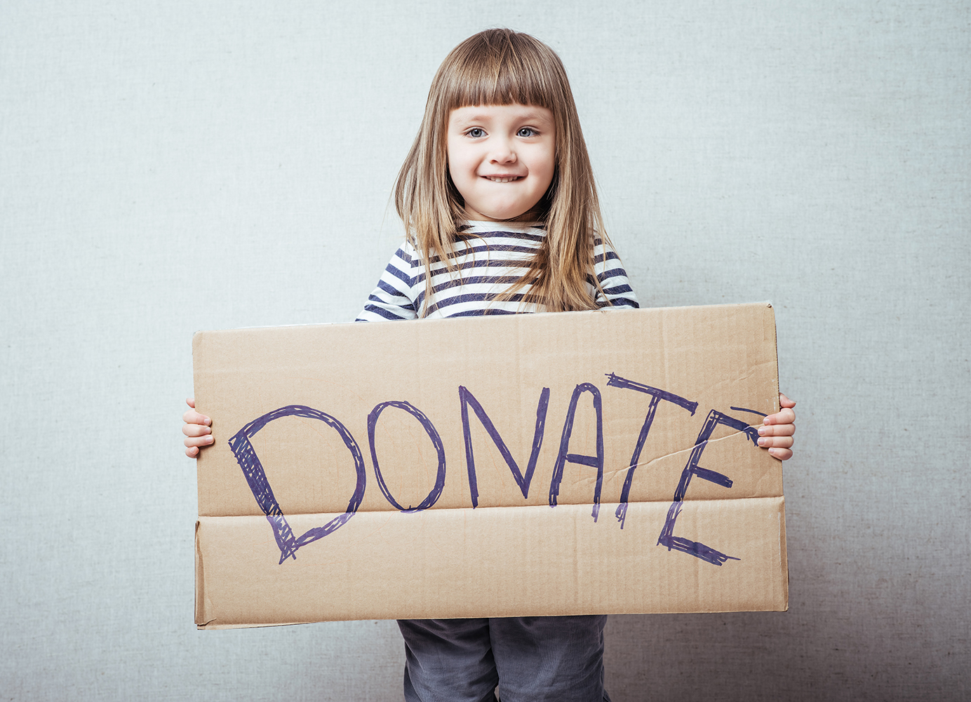 Child holding a DONATE sign